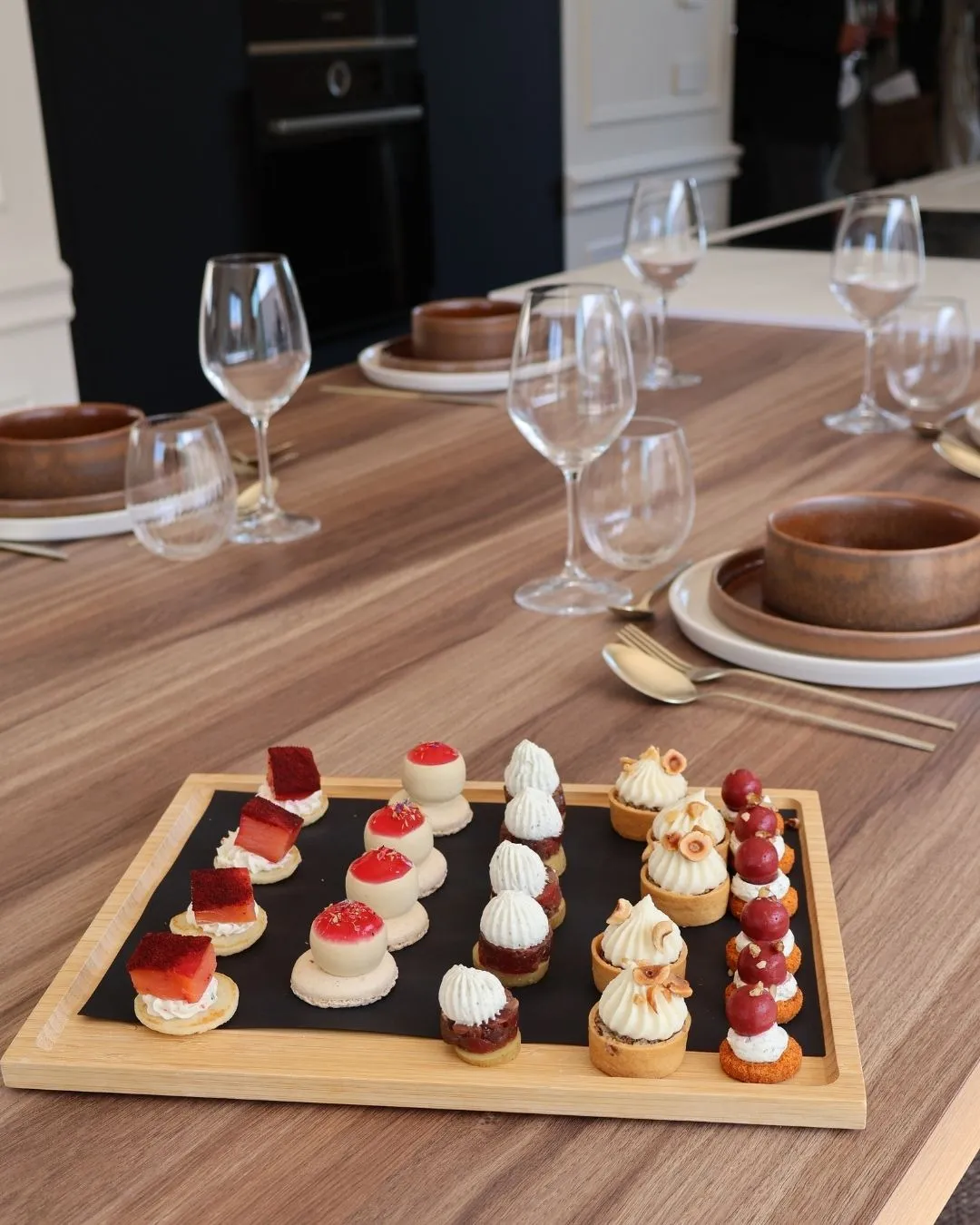 Plateau de mignardises aux fruits rouges posé sur la table dressée de la cuisine.
